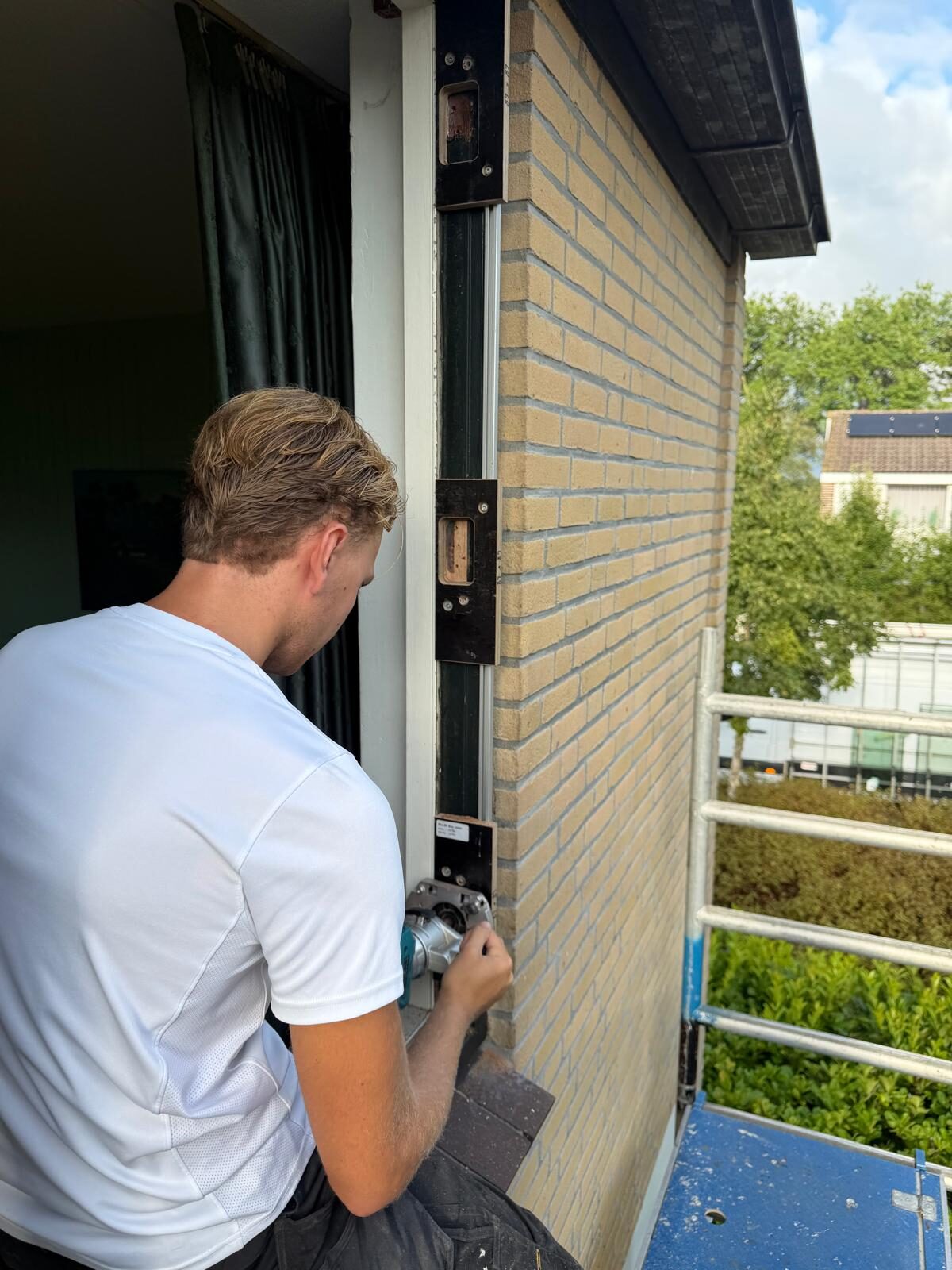 Vakman van Veloure Geveltechniek werkt aan een kozijn op locatie in West-Friesland
